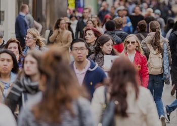 A bustling urban street scene with a diverse crowd of pedestrians.